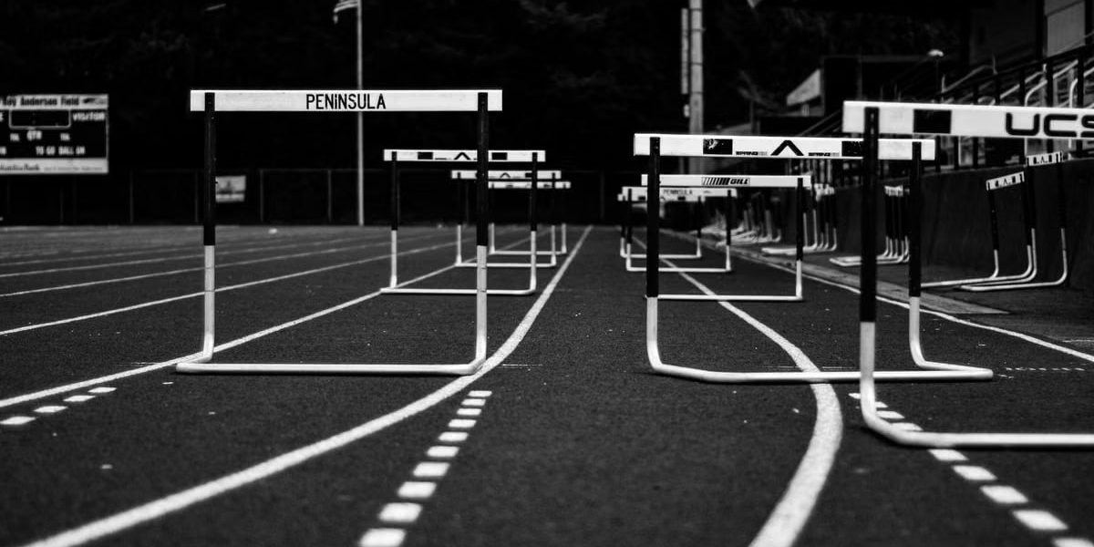 Monochrome image of hurdles on an empty sports track, perfect for athletic themes.