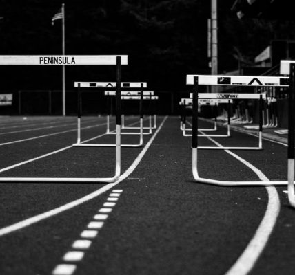 Monochrome image of hurdles on an empty sports track, perfect for athletic themes.